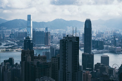 View of buildings in city against cloudy sky