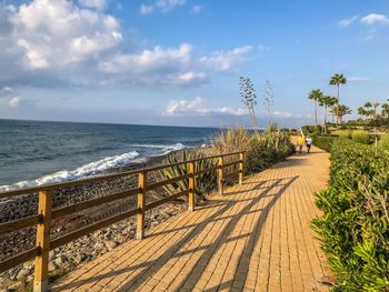 Footpath by sea against sky