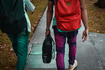 Rear view of people walking on footpath