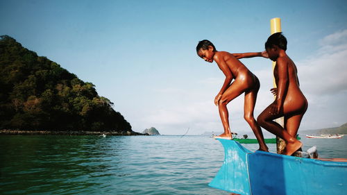 Men in bikini on sea against sky