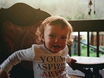 Portrait of happy girl sitting on chair