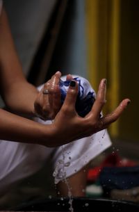 Midsection of man holding hands in water