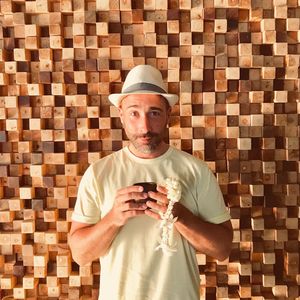 Portrait of man wearing hat while standing against wall