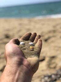 Close-up of human hand on sand