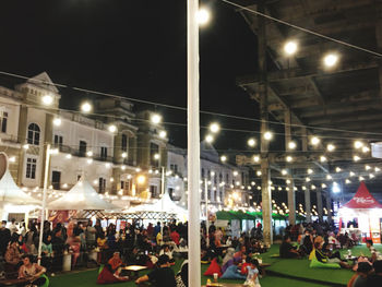 People on illuminated street at night