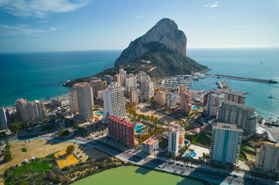 High angle view of city by sea against sky