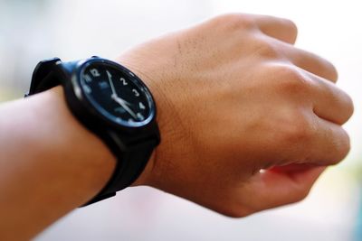 Close-up of human hand wearing wristwatch