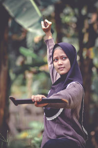 Portrait of smiling young woman using mobile phone