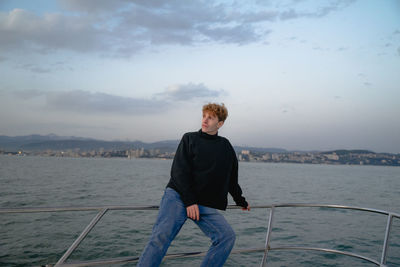 Man leaning on railing on yacht