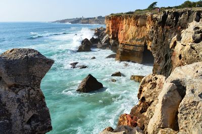 Scenic view of rocks in sea against sky