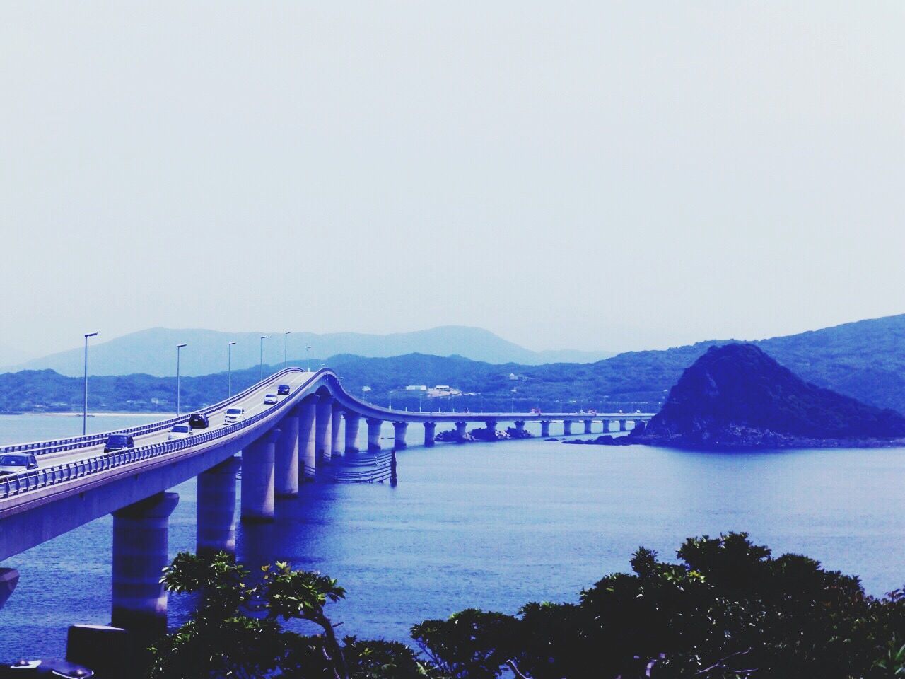 clear sky, water, mountain, bridge - man made structure, connection, copy space, built structure, tranquility, tranquil scene, bridge, scenics, architecture, river, beauty in nature, mountain range, nature, sea, railing, engineering, travel destinations