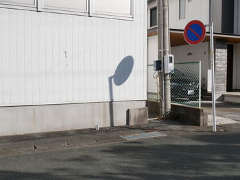 Road sign on street against building