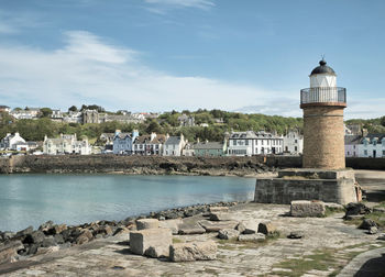 Buildings by sea against sky