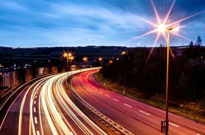 Road passing through illuminated city at night