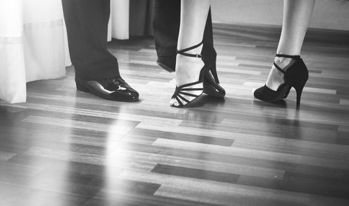 Low section of couple dancing on parquet floor