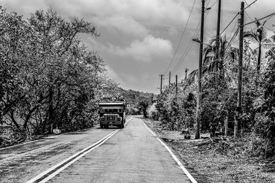 Road amidst trees against sky