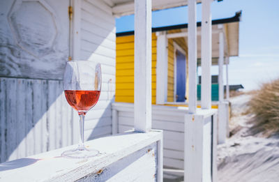 Close-up of wine glass on hut veranda.