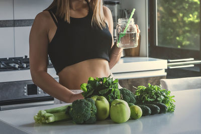 Midsection of woman holding food at home