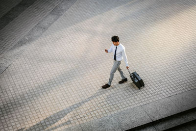 Full length rear view of a man walking on footpath