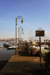 Boats moored at harbor against clear sky