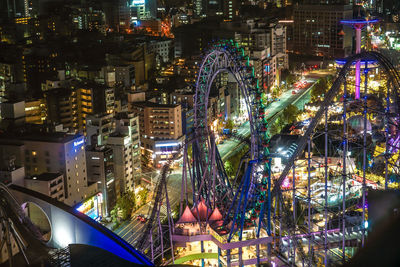 High angle view of illuminated ferris wheel in city at night