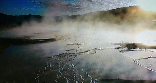 Scenic view of waterfall against sky