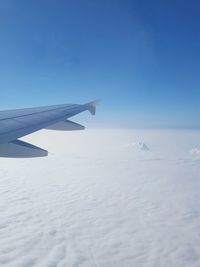 Cropped image of airplane flying over clouds