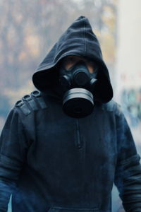 Man wearing gas mask standing outdoors 