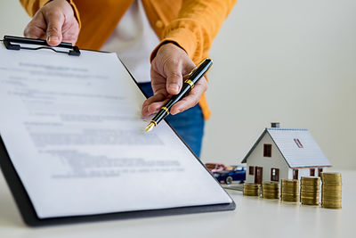 Midsection of man reading book on table