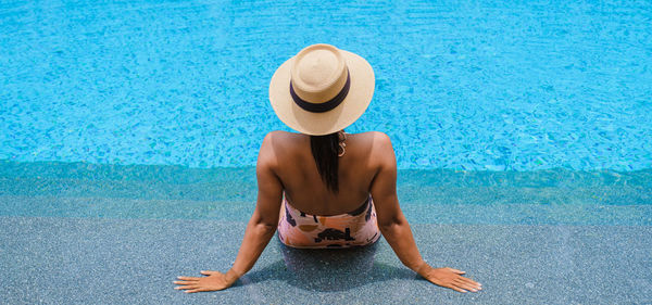 Low section of woman wearing hat on beach