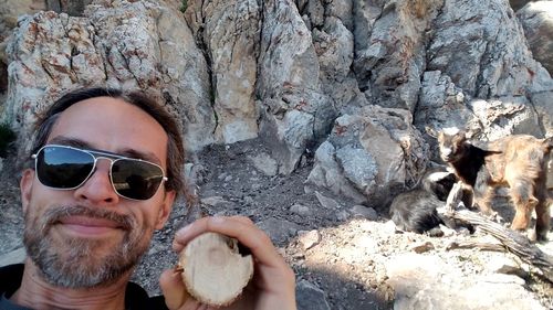Portrait of man with sunglasses eating rock