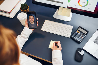 Entrepreneur having business call on phone. woman making notes while talking to her business partner