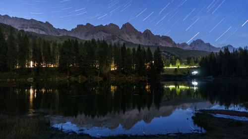 Scenic view of lake against star trails at night