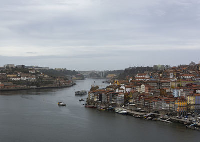 Aerial view of townscape by sea against sky