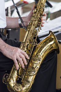 Midsection of man playing saxophone