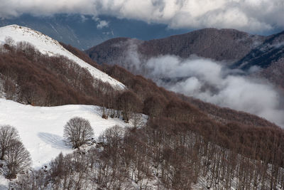 Scenic view of snowcapped mountains against cloudy sky