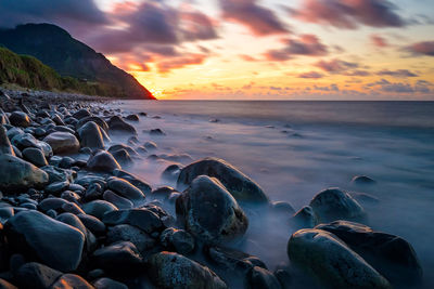 Sunrise at valugan boulder beach in batanes, philippines. scenic view of sea against sky. 