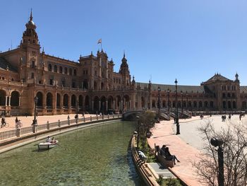 View of canal and buildings against clear sky