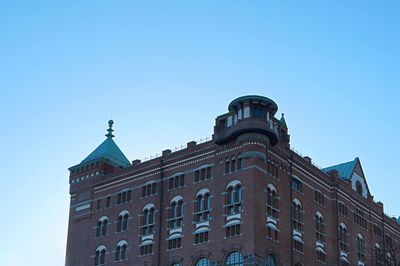 Low angle view of old building against clear blue sky