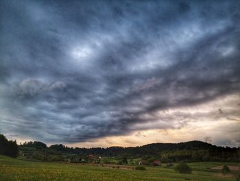 Scenic view of field against cloudy sky