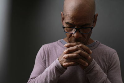 Portrait of man wearing eyeglasses against black background