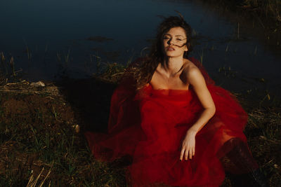 Portrait of young female model posing at lakeshore