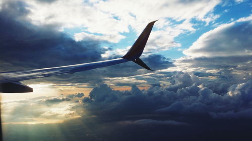 Airplane flying over cloudscape against sky