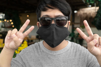 Portrait of young man wearing sunglasses standing outdoors