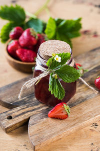 Strawberry jam in a jar on a wooden board. fermented berries.