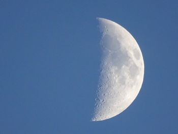 Low angle view of moon against clear blue sky