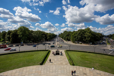 Panoramic view of people in park against cloudy sky