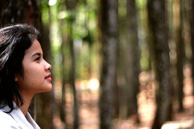 Portrait of woman looking away in forest