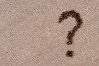 Question mark symbol made from a coffee beans on a burlap sack.