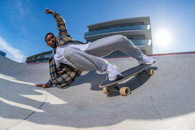 Low section of man skateboarding on street